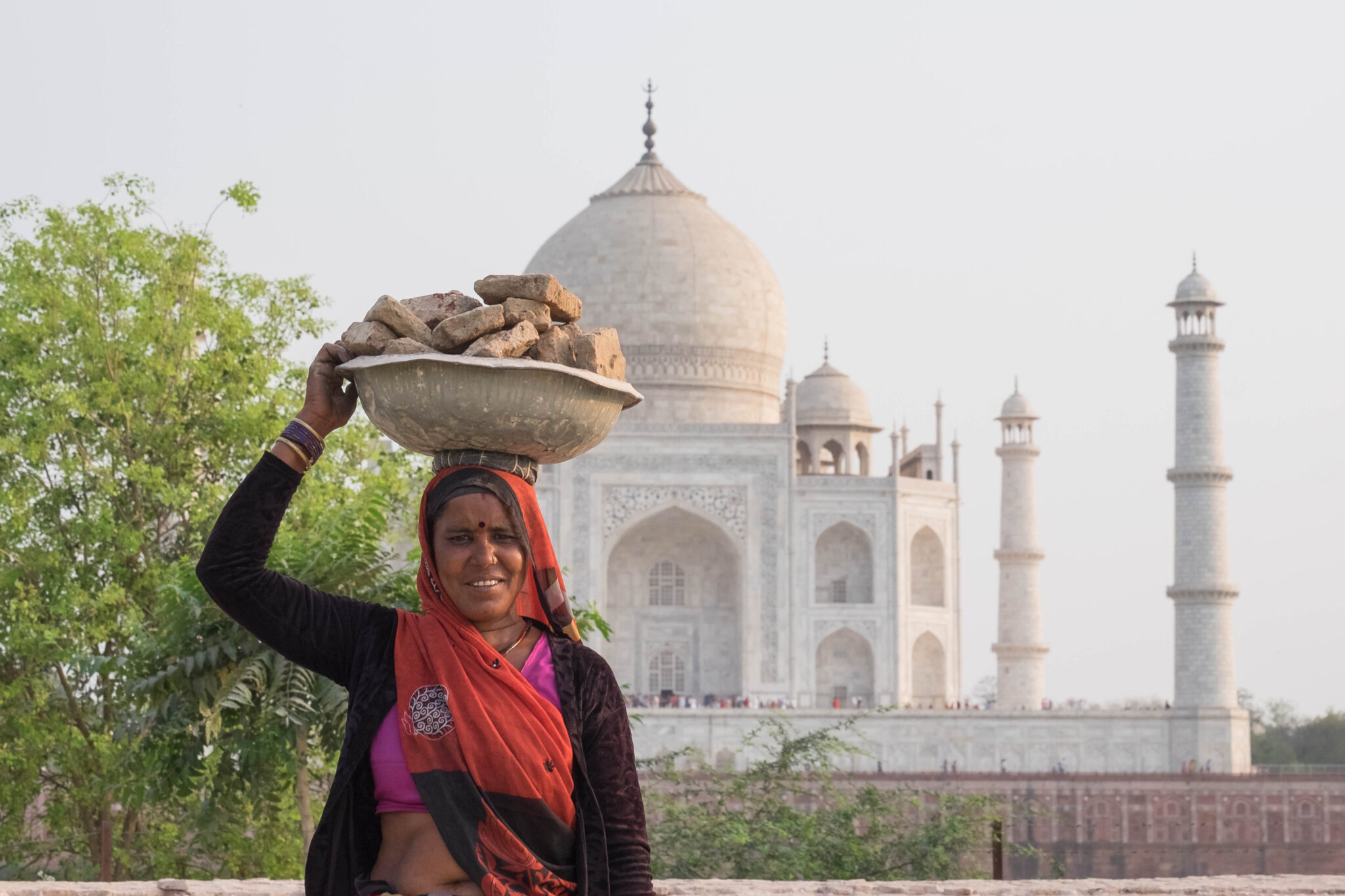 an indian woman posing in front of the taj mahal