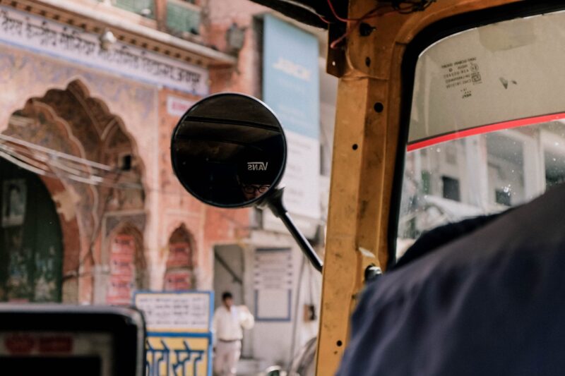 A selfie in the mirror of a tuk tuk while driving through Jaipur, India