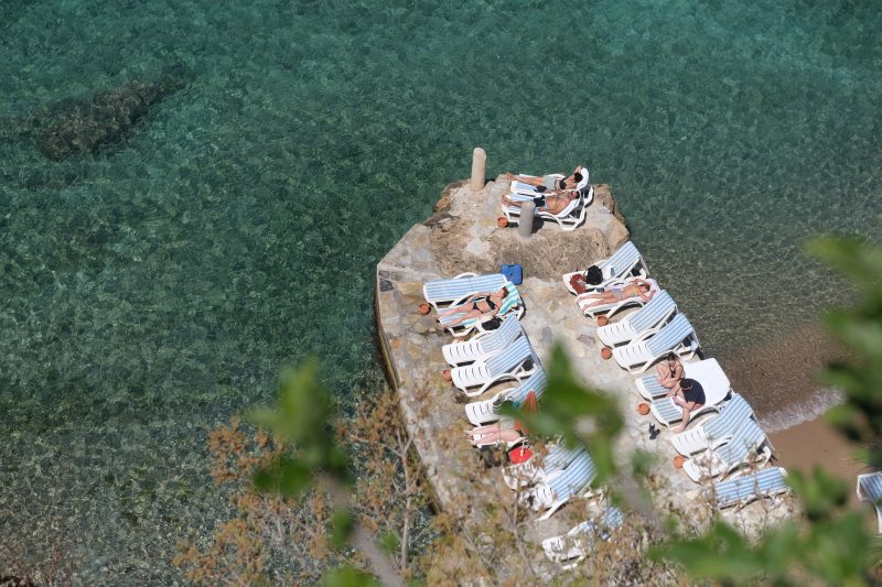 People sunbathing on a jetty at the beach near Antalya Harbour, Turkey